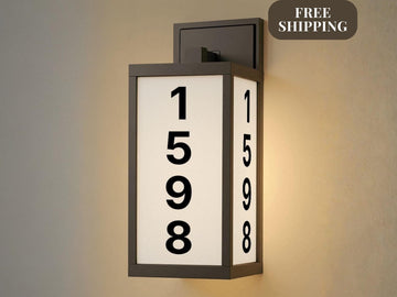 modern personalized address light with illuminated house numbers on front porch at night