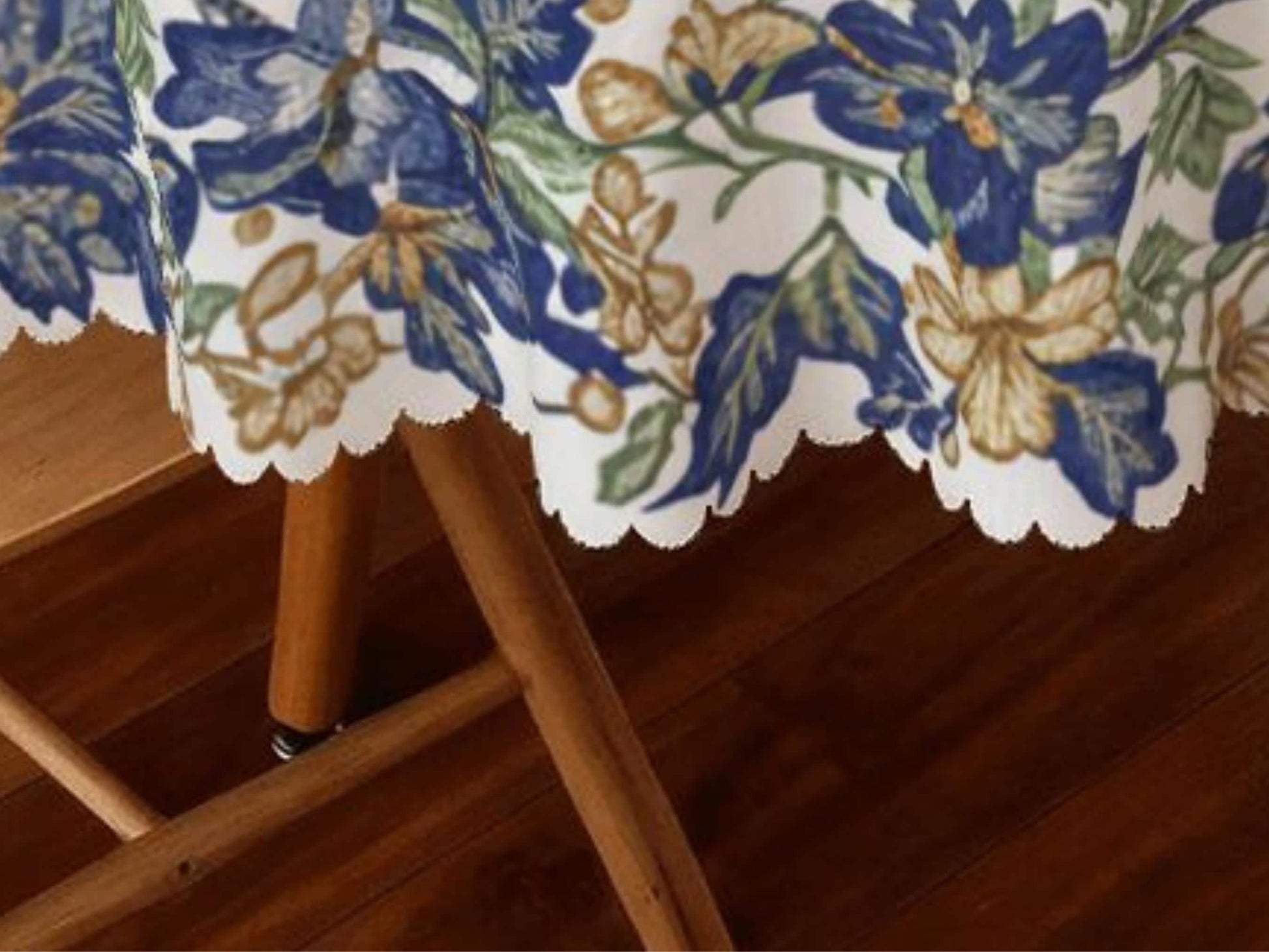 a wooden table with a floral tablecloth, and the table is situated on a wooden floor.
