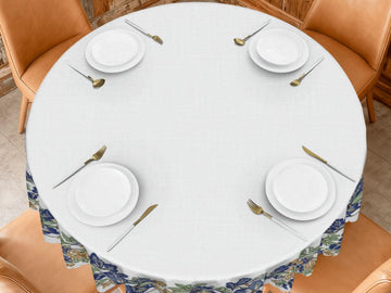 a table set for a meal, with four white plates, gold cutlery, and a white tablecloth.
